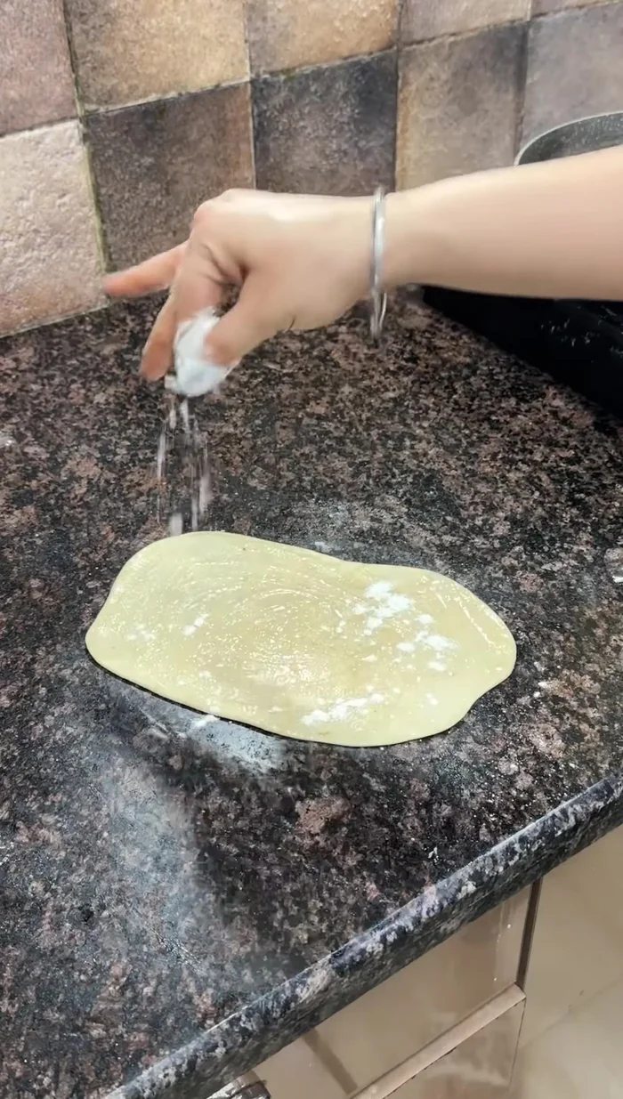 Prepare the roti: Divide the rested dough into equal portions. Roll out each portion thinly, giving it pleats. Cook on a hot pan like a paratha, applying oil after cooking for crispiness.