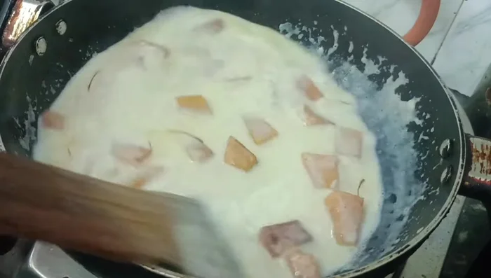 Add saffron strands and cardamom powder for flavor.