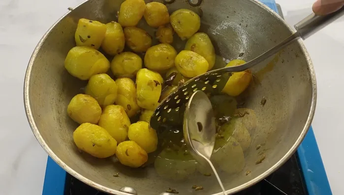 Remove excess oil from the potatoes.