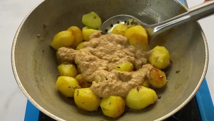 Add the poppy seed paste to the potatoes and mix well. Cover and cook for 1-2 minutes until the paste is cooked and the flavors meld.