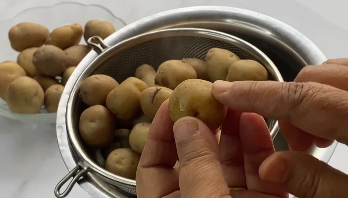 Remove the potatoes from water and let them cool. Peel the potatoes.