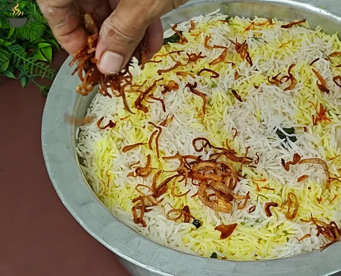 Add some fried onions on top. Cover with aluminum foil and a lid, and add weight on top.