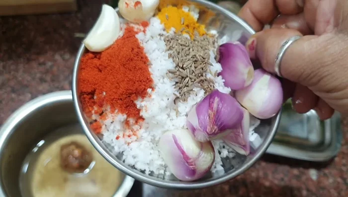 Grind coconut, cumin seeds, coriander powder, garlic, and small onions to a smooth paste.