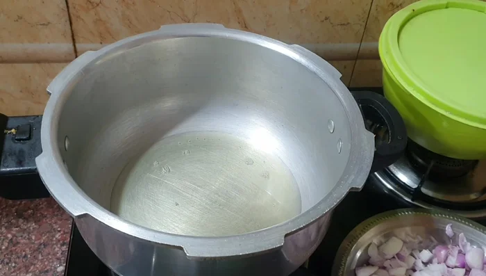 Heat sesame oil in a cooker. Add fennel seeds, bay leaf, mint leaves, and coriander leaves for seasoning.