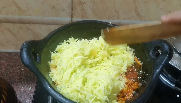 Add the grated mango to the pan. Stir well.