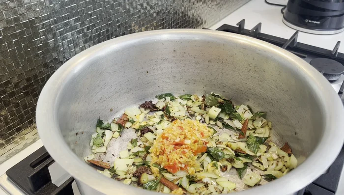 Add crushed ginger, garlic, chili, and coriander roots. Cook until fragrant.