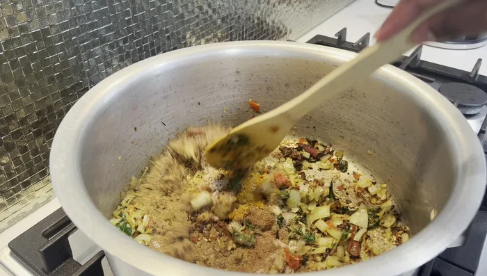Add turmeric, salt, and a little water to cook the masala. Cook until oil separates and masala is fragrant.