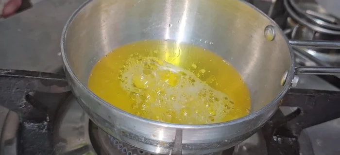 Prepare tempering: Heat ghee, add crushed garlic and sautéed onions until light golden brown. Add red chili powder, mix well, and add to the dal.