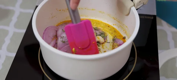 Switch on the flame and cook until onions soften. Add a pinch of salt.