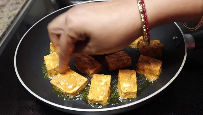 Apply any remaining marinade paste to the tofu. Flip the tofu and cook until golden brown on both sides.