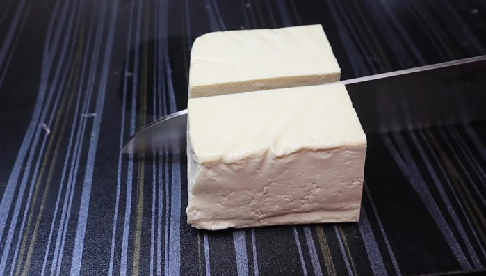 Press the tofu to remove excess water. Wrap it in a cloth, place it on a sieve, and put a heavy object on top.