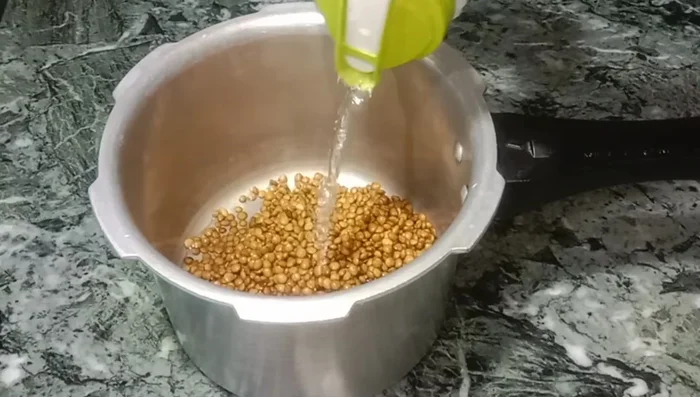 Add lentils to a pressure cooker. Add 1 cup of water, 1 teaspoon of oil, and 1 spoon of salt.