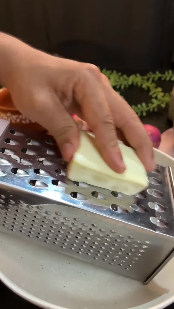 Grate the paneer. The amount needed is not specified.