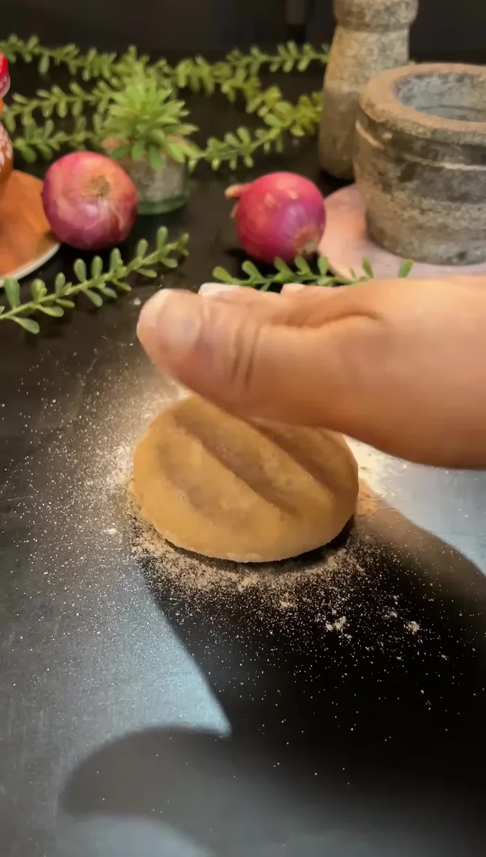 Sprinkle dry flour on each peda and flatten it with your hands.