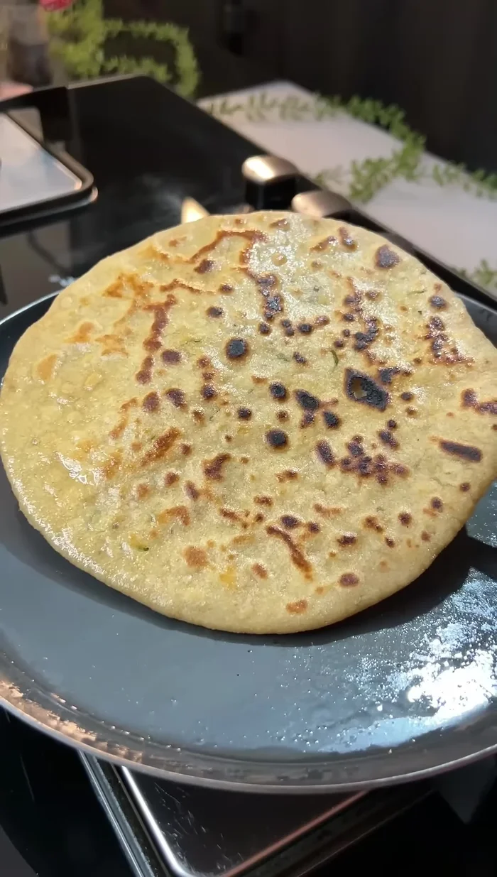 Apply ghee to both sides of the paratha while cooking.
