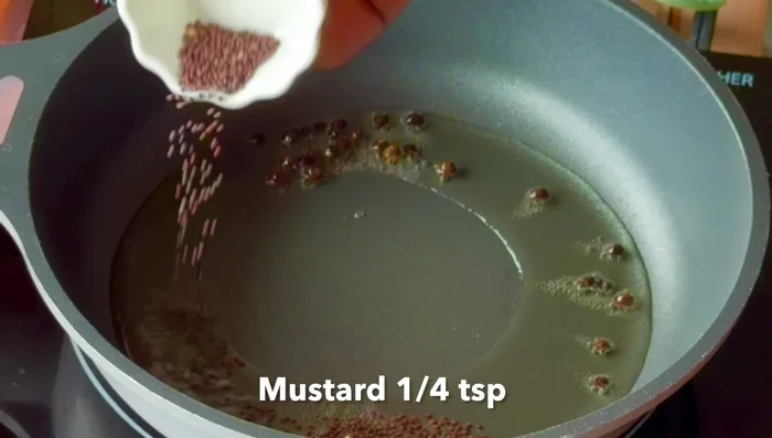 Prepare the tempering: Heat oil in a pan, add peppercorns, mustard seeds, cumin seeds, fenugreek seeds, red chilies, chopped small onions, and curry leaves. Sauté until fragrant.