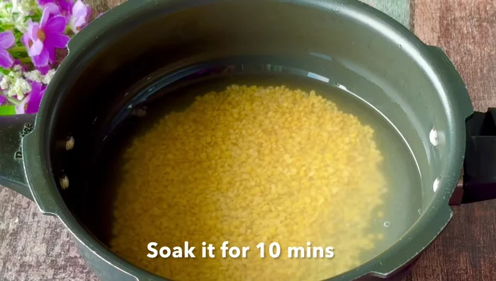 Wash the dal two or three times and soak it with a little water for 10 minutes.