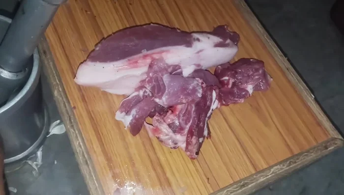 Grind the pork meat into mince using a grinder.