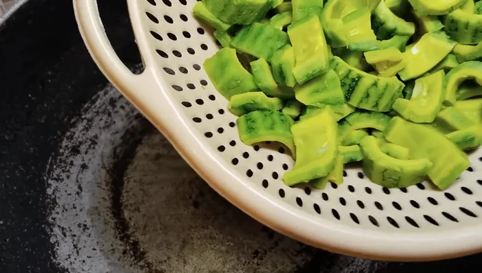 Heat oil in a pan and fry the bitter gourd until the color changes (about 7-8 minutes).