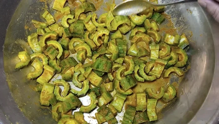 Mix the chopped bitter gourd with salt, turmeric, and lemon juice. Let it sit for 30 minutes.