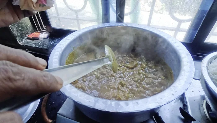Once the canals release their moisture and the gravy thickens, add the pre-boiled biryani rice in layers.