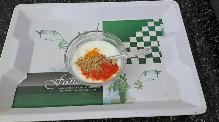 Mix curd with green chilies, coriander powder, and turmeric.