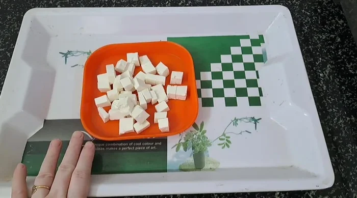 Cut paneer into square or rectangular pieces. Finely chop two onions. Slice the third onion into layers.