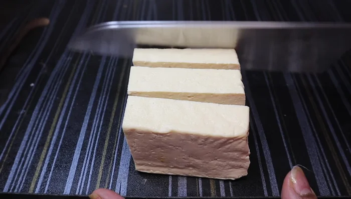 Cut the tofu into cube shapes, ensuring they are slightly thick to prevent breaking during frying.