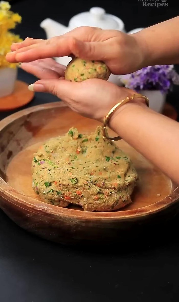 Take a portion of the dough, roll it into a ball, and flatten it slightly. Coat with dry flour to prevent sticking.