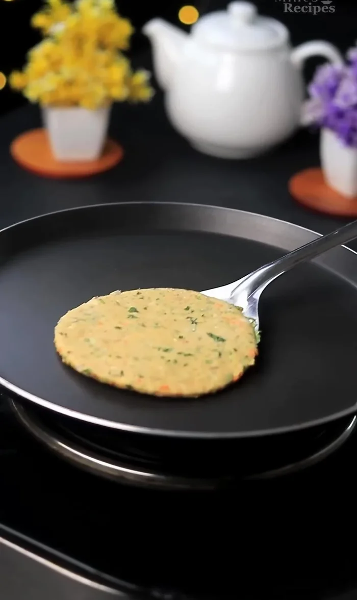 Heat a tawa (griddle). Cook the paratha on medium heat, flipping after 2 minutes. Apply ghee (or butter/oil) to both sides while cooking.