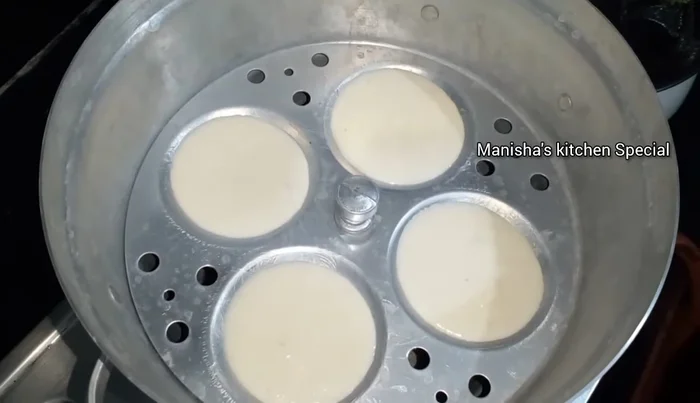 Place the idli moulds on the steamer stand. Steam over medium-low heat for 10-12 minutes.