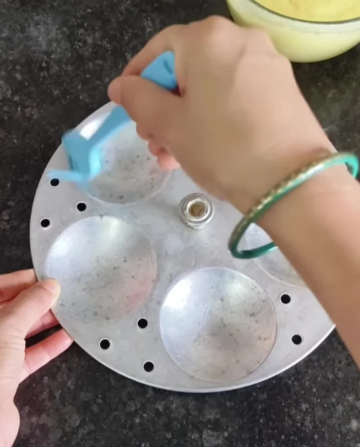 Grease an idli mold with oil. If using a bowl, grease that as well.