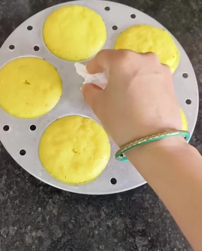Turn off the heat and let the idli dhokla cool slightly before removing from the molds.