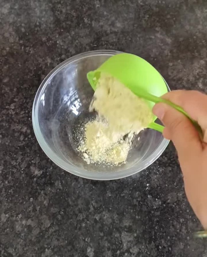 In a vessel, combine gram flour, semolina, curd, turmeric powder, and salt. Mix well.