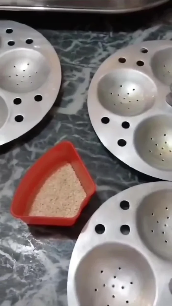 Grease the idli stand and pour the batter into the molds.