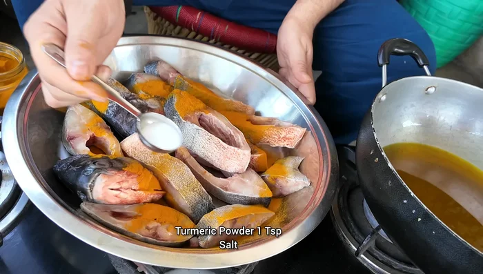 Apply turmeric powder and salt to the fish. Mix well.