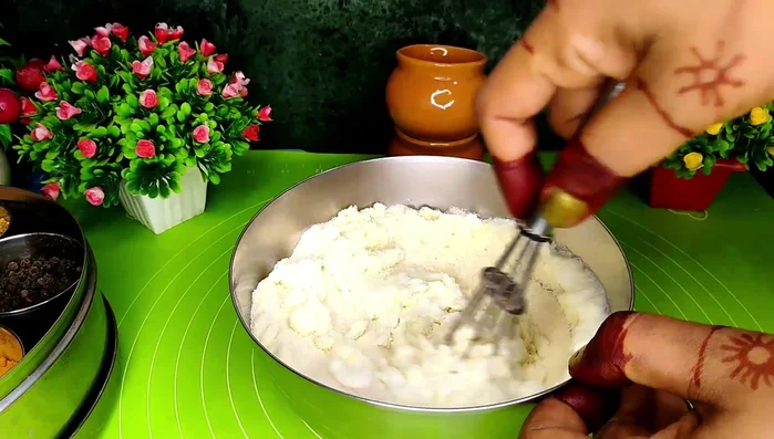 Make the idli batter: In a bowl, combine semolina, salt, sugar, curd, and water. Mix well to create a lump-free batter (97.36). Cover and let it rest for 10 minutes (117.84).