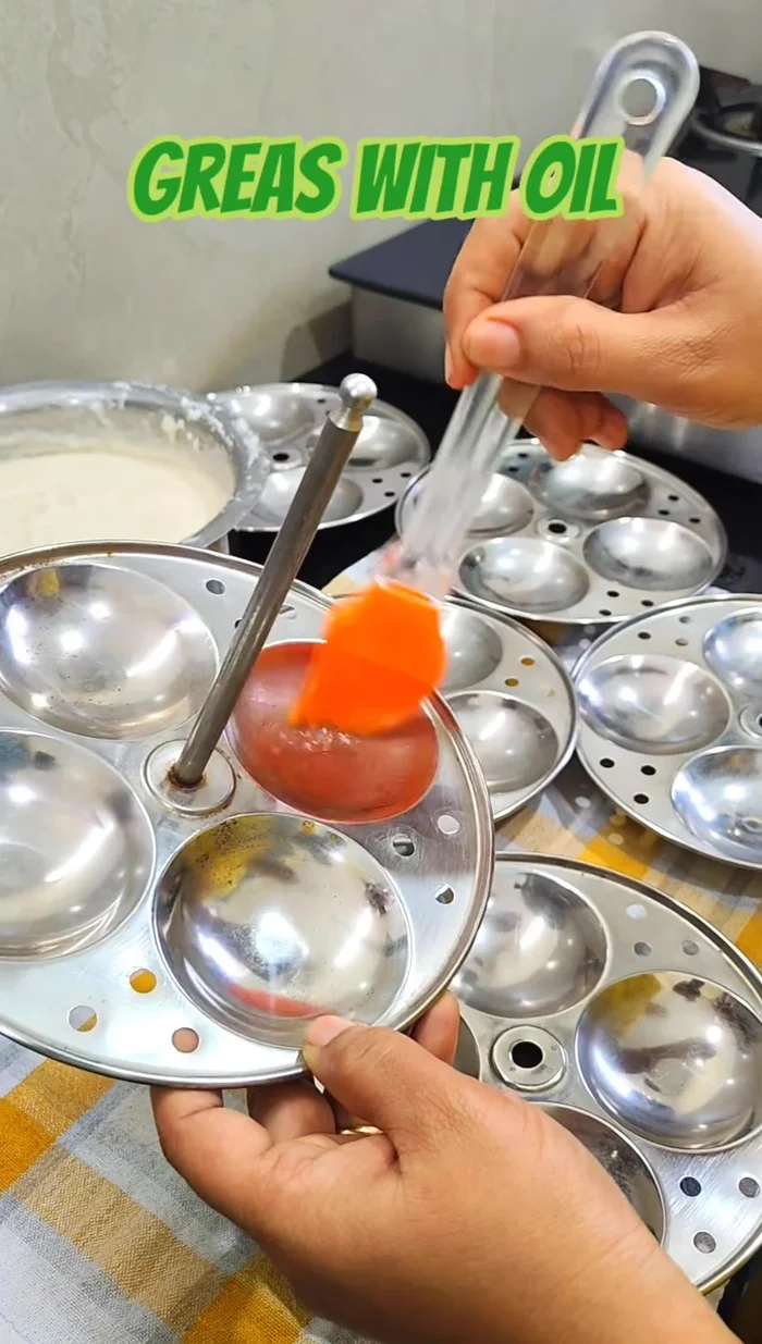 Grease the idli mould with oil.