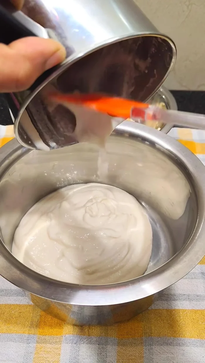 Transfer the urad dal paste to a large pan. Ensure the pan is larger than needed as the batter will double in size after fermentation.
