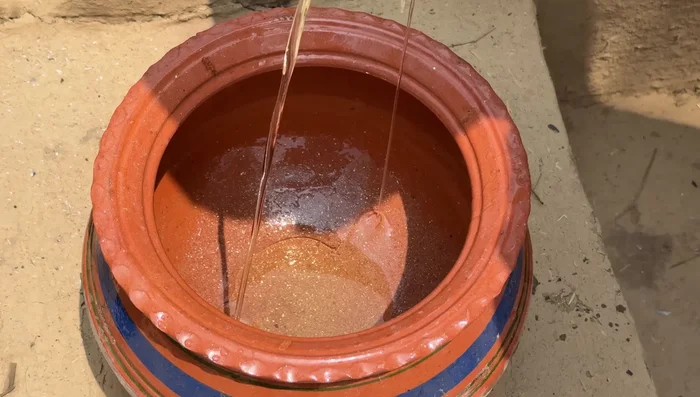 Heat cooking oil in a handiya (cooking pot) and sauté onions and garlic until golden brown.