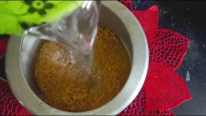 Cook arhar dal with water, turmeric, and salt in a pressure cooker until 2-3 whistles.