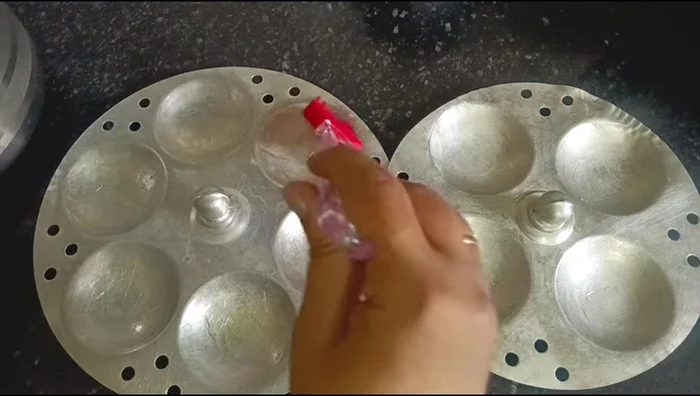 Add salt to the batter. Grease idli molds with oil, pour batter, and steam for 10-12 minutes.