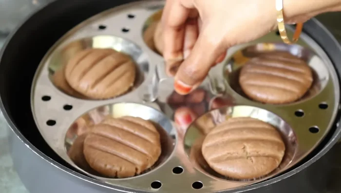 Heat a medium-sized pan, place a ring (if using) in it. Place the idli plate on the pan and cover with a lid.