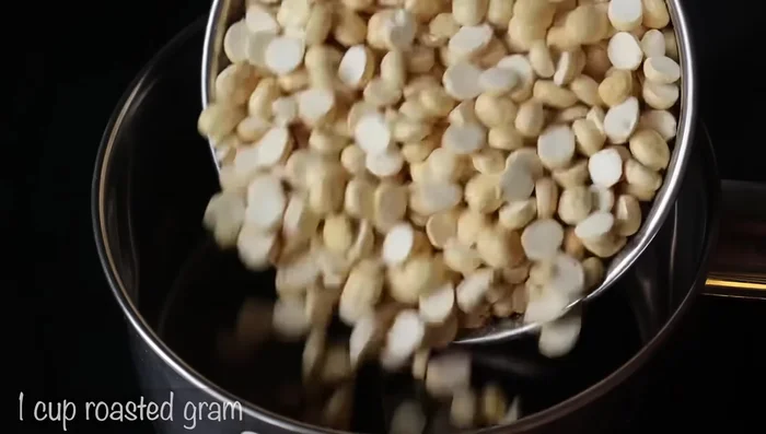 Grind 1 cup of peanuts into a fine powder using a mixie jar.
