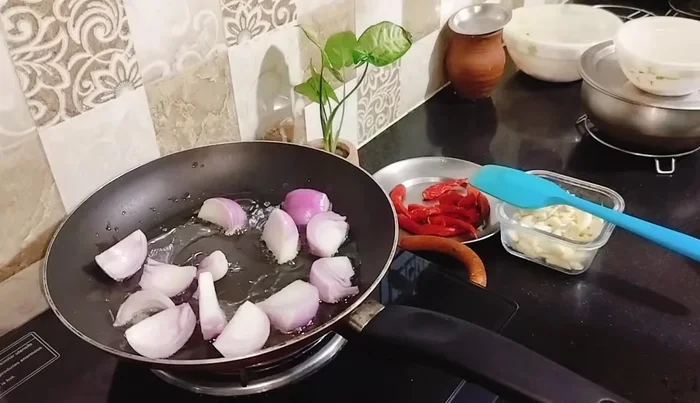 Heat refined oil in a pan. Add roughly chopped onions and fry for 2 minutes until slightly transparent.
