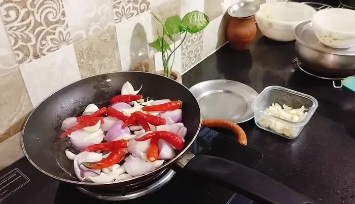 Add garlic and chilies. Fry for 3-4 minutes until the onion and garlic color changes slightly.