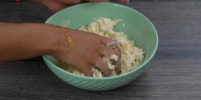 Gradually add 2-3 tablespoons of water and knead into a soft dough.