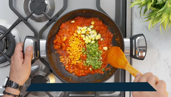 Cook the sauce until the oil separates. Add capsicum, carrot, corn, or other desired vegetables.