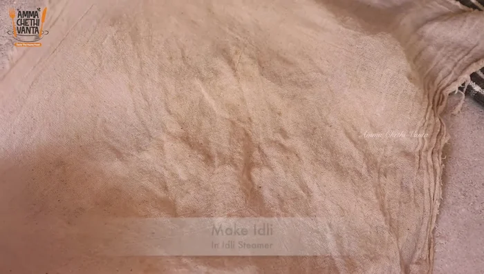 Grease idli molds with ghee or use a wet cotton cloth. Fill molds with batter.