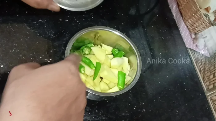 Prepare the chutney: Blend raw mangoes, green chilies, garlic, coriander leaves (with stalks), salt, and sugar in a grinder without adding water.